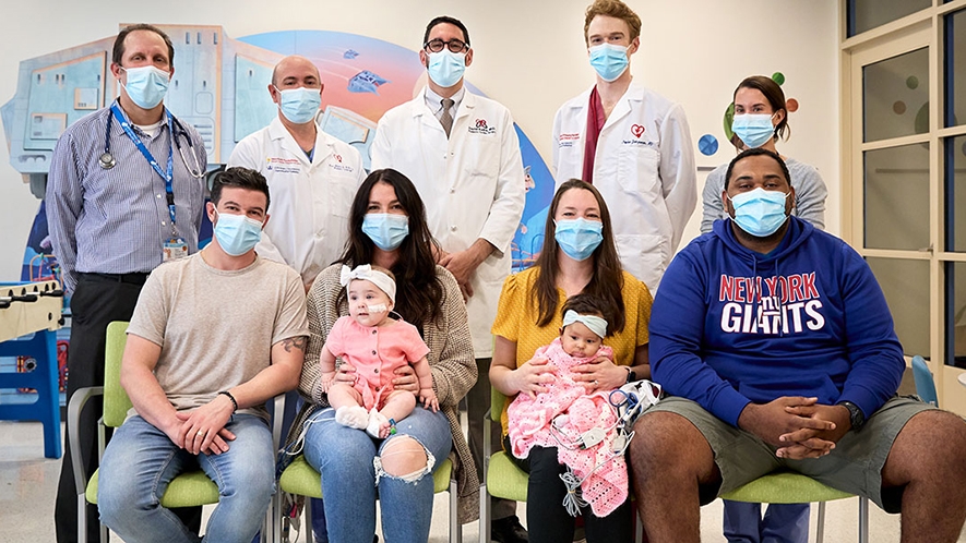 The Skaats and Civil families with members of their care teams. Front, left to right: James Skaats; Nicole Skaats, with Mia; Sam Civil, with Brooklyn; Andre Civil. Back, left to right: Dr. Warren Zuckerman; Dr. Marc Richmond; Dr. David Kalfa; Dr. Stephan Juergensen; nurse practitioner Jennie McAllister (Image courtesy of NYP)