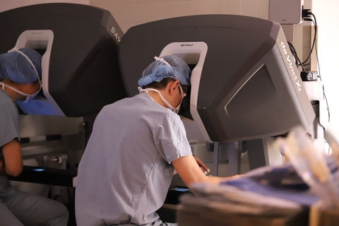 Seated surgeon looking into a da Vinci Xi robotic system